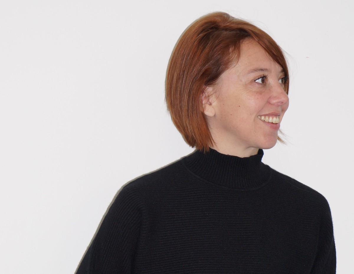 A smiling white woman in a black turtleneck.