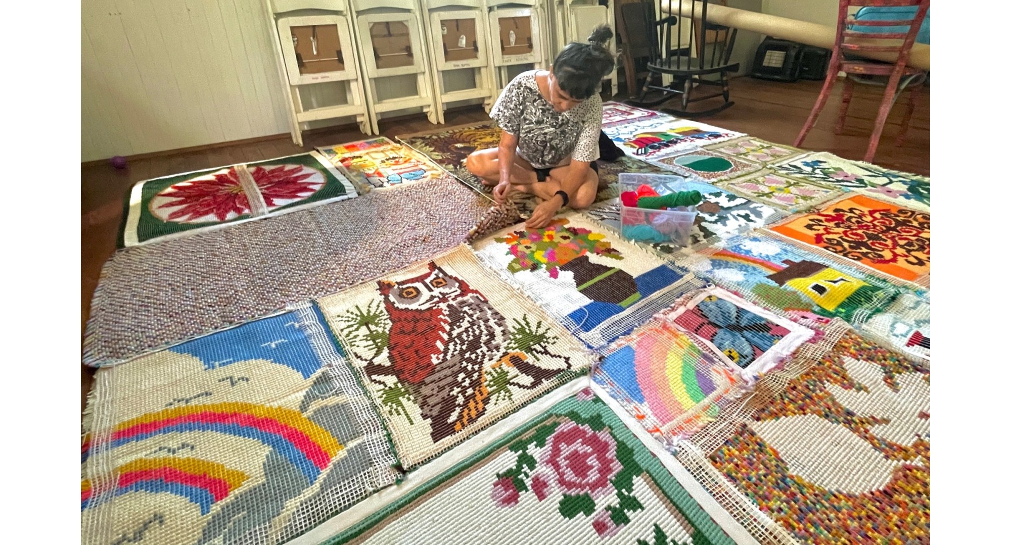 Jacinta Bunnell building a large 3D structure out of latch hook rugs.
