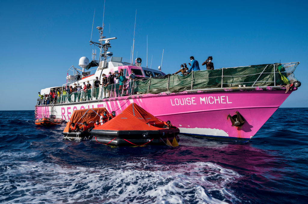 Crew members of civil sea rescue ship Sea-Watch 4 on inflatable boats help migrants to get off the rescue ship funded by British street artist Banksy "Louise Michel" off the coast of Malta, on August 29, 2020. - An Italian coastguard vessel on August 29, 2020 had rushed to "Louise Michel" after it sent out a call for help with more than 200 migrants onboard, and took in 49 of the most vulnerable people on board. The Sea-Watch 4 vessel, that has a clinic and already rescued 201 migrants onboard and is itself in search of a host port, also arrived and took over 150 migrants from "Louise Michel". (Photo by Thomas Lohnes / AFP) / Germany OUT (Photo by THOMAS LOHNES/AFP via Getty Images)